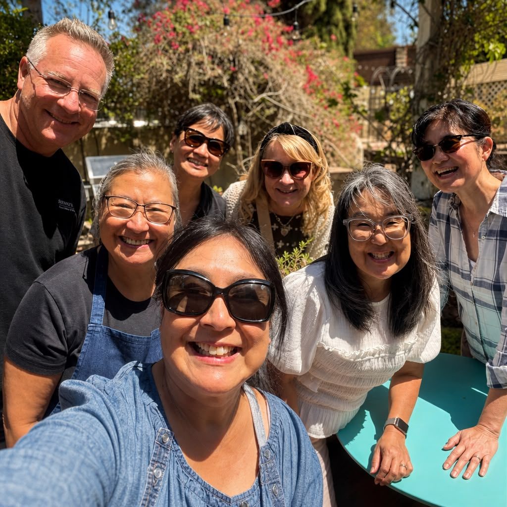 Sienne with six lunch guests gathered around a turquoise patio table under the bougainvillea — Patio Lunch at Sienne's Table, Lomita CA