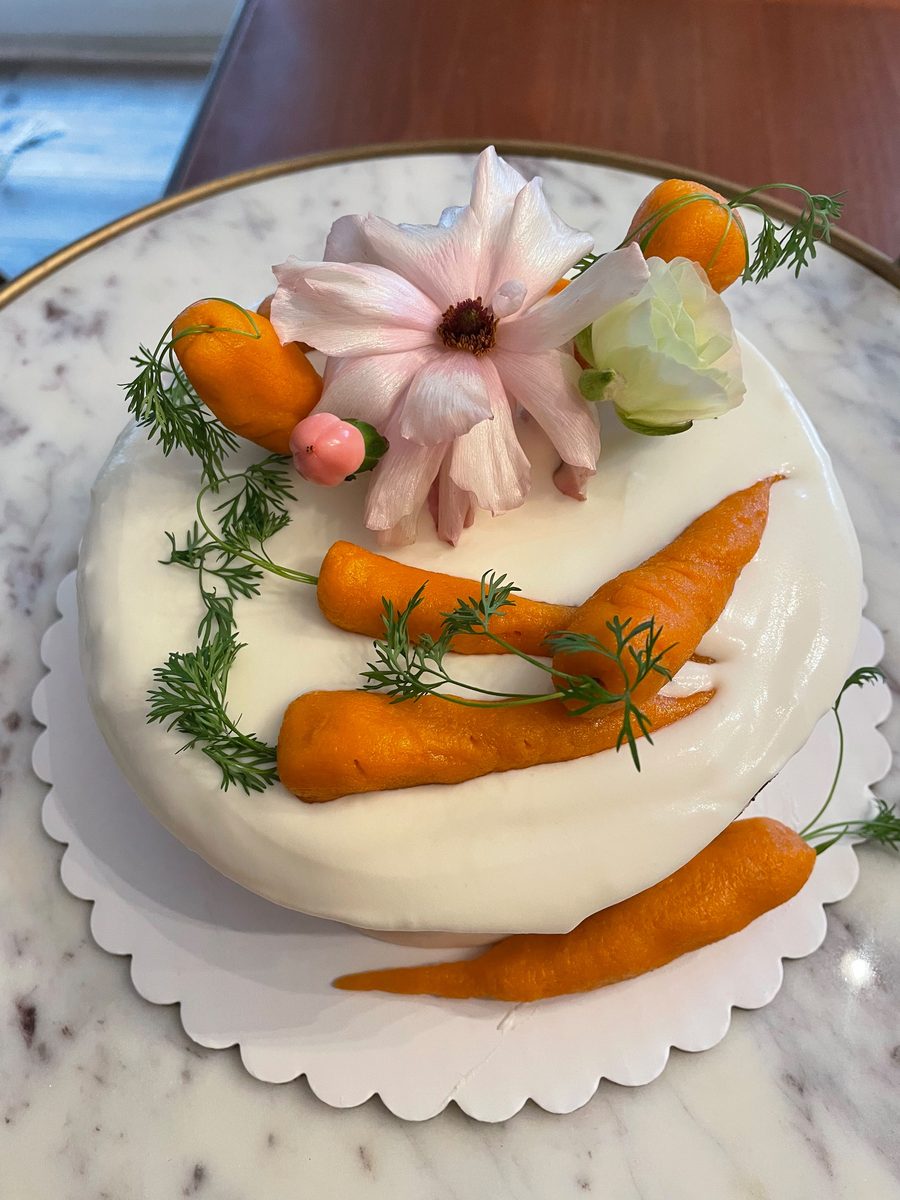 Carrot cake finished with cream cheese frosting, marzipan carrots, dill fronds, and a pale pink ranunculus — Sienne's Table, Lomita CA