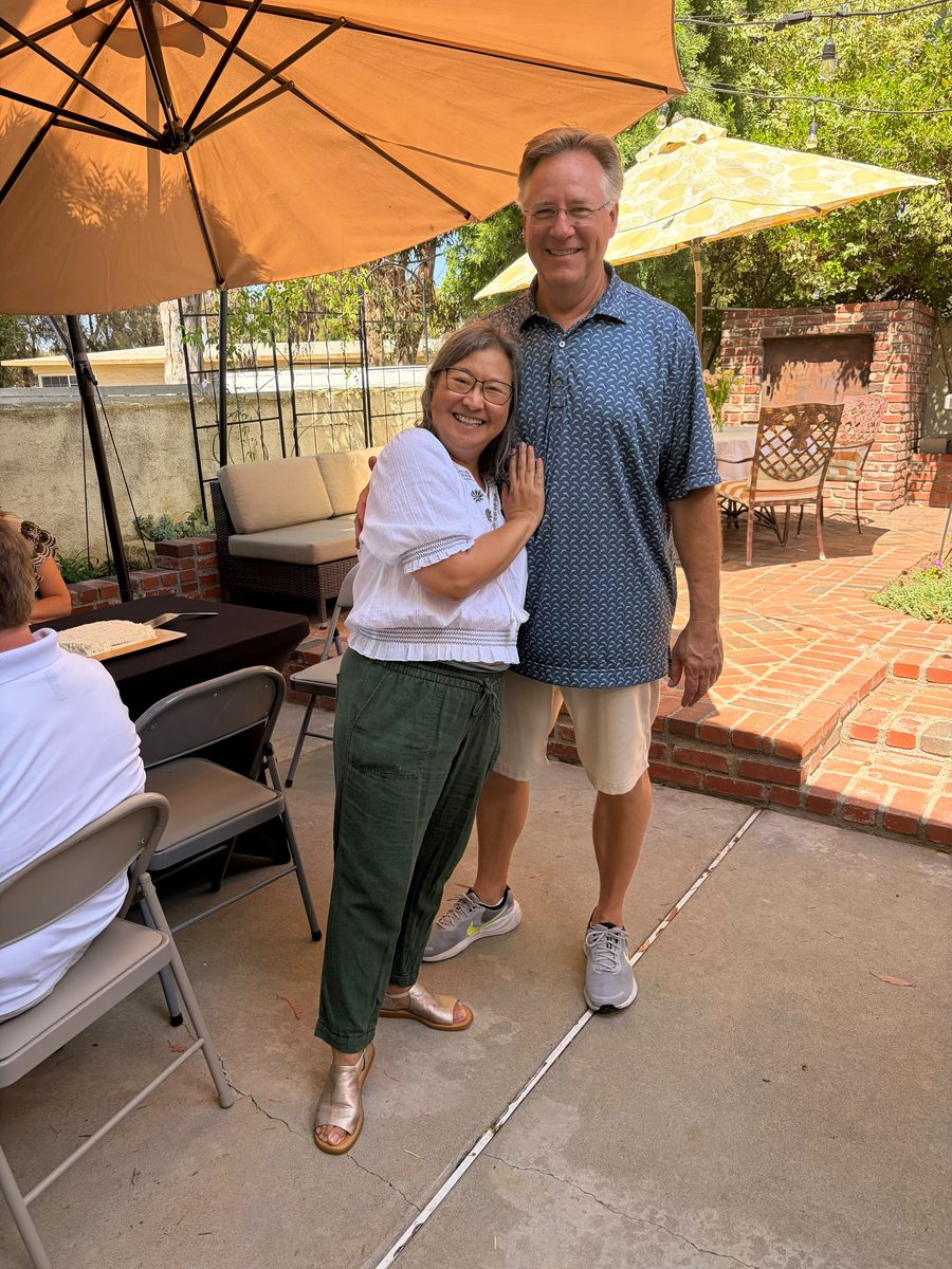 Sienne welcoming a guest with a hug on the patio during the Open House