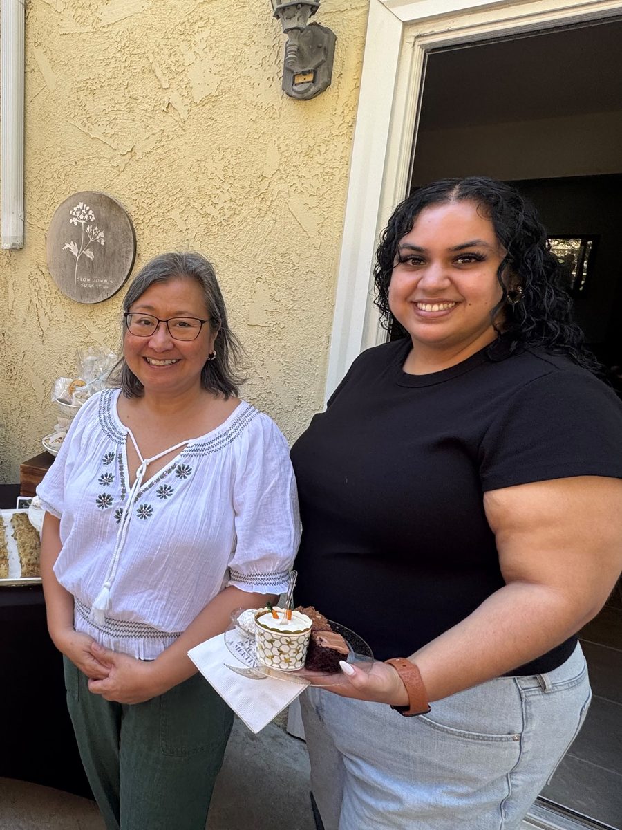 Sienne and a guest beside the dessert table of lemon bars, baklava, and almond bars at the Open House