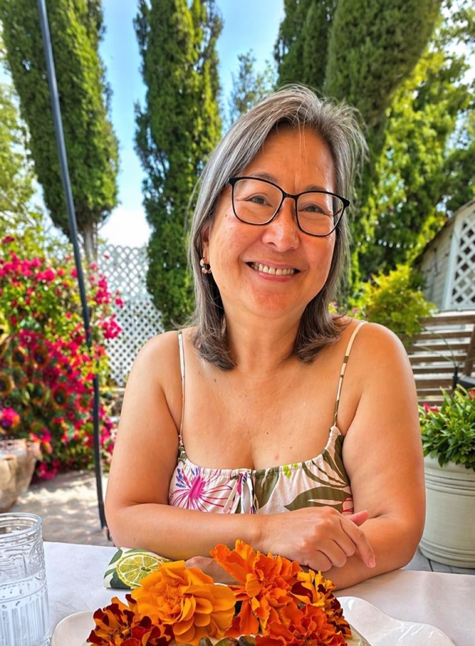 Sienne, smiling on her patio, surrounded by bougainvillea