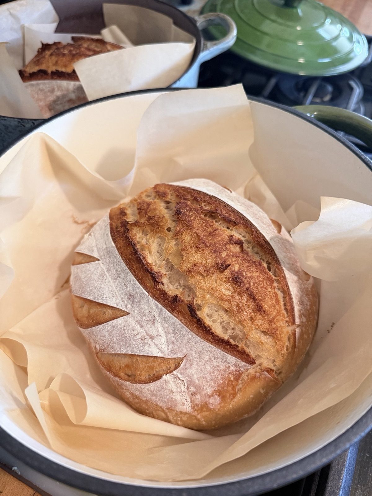Naturally leavened sourdough boule, deeply scored, resting in its Dutch oven — Sienne's Table artisan bakery, Lomita CA