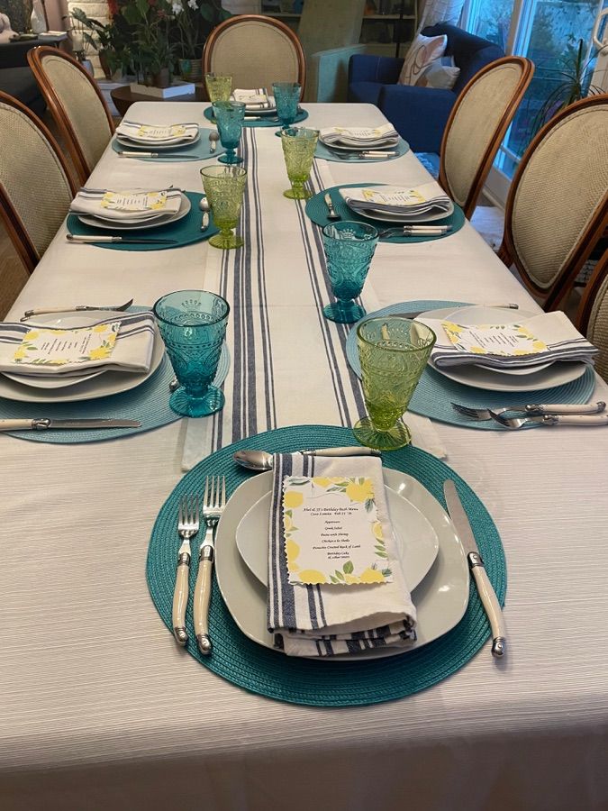 Elegantly set dinner table with teal accents and hand-written menus — a glimpse of Sienne's patio dinners
